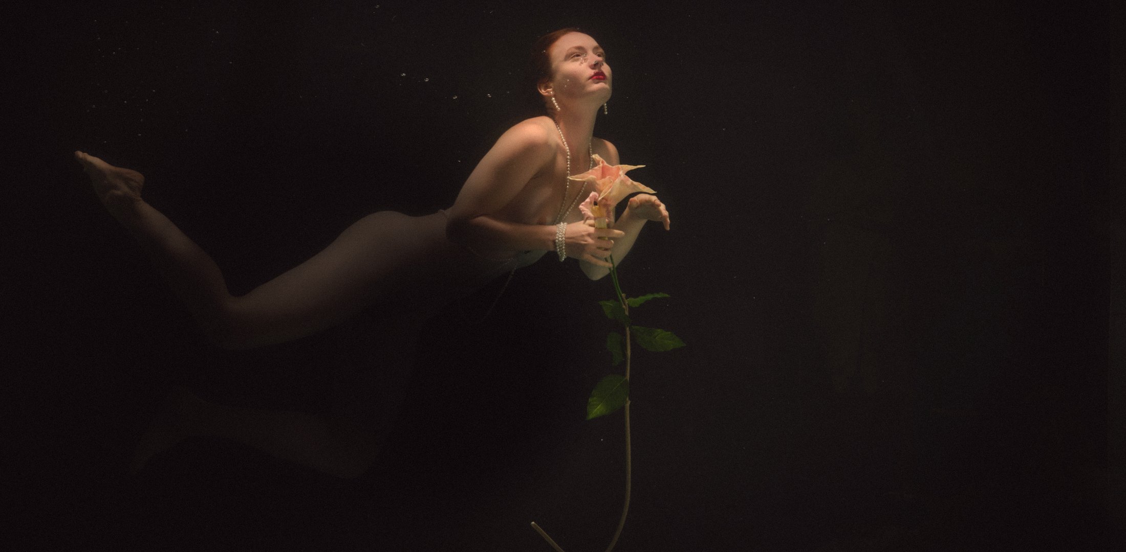 Daniela taucht mit einer Blüte in der Hand